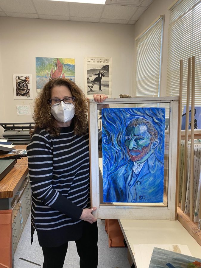 Hartman holds up a painting by Mr. Mazouat gave her of her favorite artist, Vincent Van Gogh, that was used as a sample for the library window art project in his Art 1 class in 2020.
