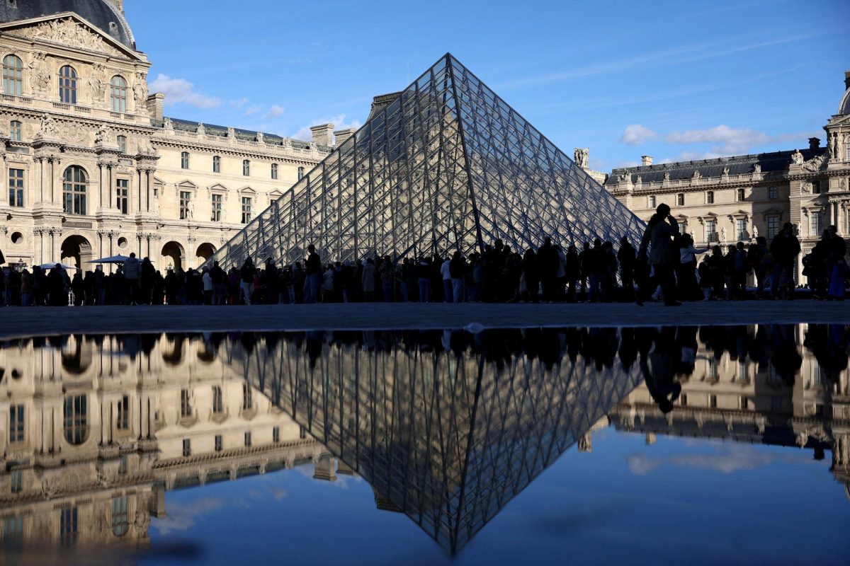 People stand outside the Louvre Museum, after French police arrested suspects in the Louvre heist case, in Paris, France October 26, 2025. REUTERS/Abdul Saboor